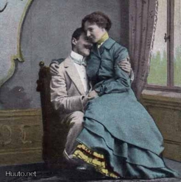RAKKAUS / Hymyilevä tyttö istuu miehen sylissä. 1900-l.